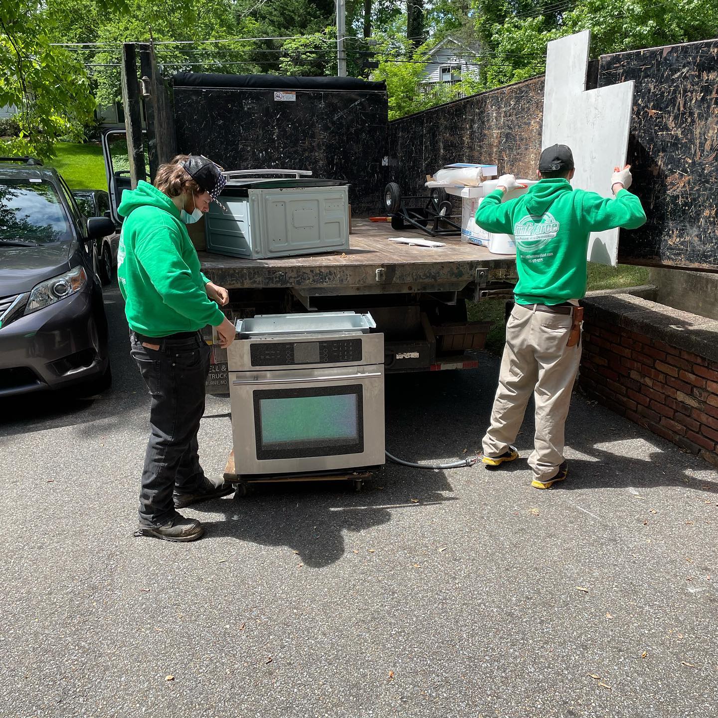 Junk Force employees haul old appliances and boxes into truck