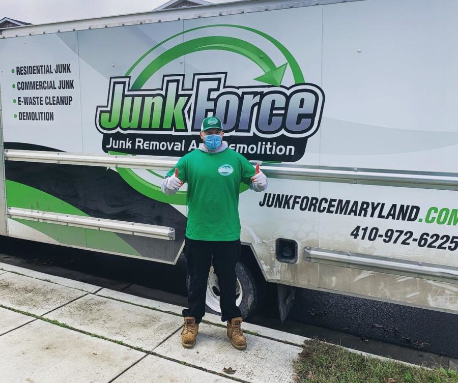 A Junk Force professional posing in front of a truck